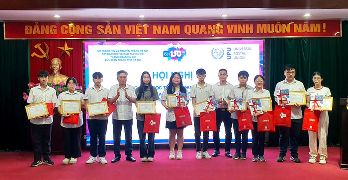 Phó Giám đốc Sở Thông tin và Truyền thông Nguyễn Tiến Sỹ tặng quà cho các em học sinh đạt giải. So thong tin HN.jpg