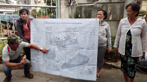 Người dân in tấm bản đồ được cho là “bị mất” căng ra trước cổng để chỉ vào khu đô thị Thủ Thiêm mà theo họ là bị giải tỏa… lố. (Ảnh: H.L) Người dân in tấm bản đồ được cho là “bị mất” căng ra trước cổng để chỉ vào khu đô thị Thủ Thiêm mà theo họ là bị giải tỏa… lố. (Ảnh: H.L)