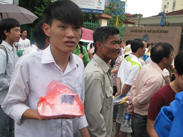 Một sĩ tử vừa thi xong môn Địa Lý tại trường HV báo chi và tuyên truyền đang bất ngờ khi cầm trên tay suấ cơm miễn phí.