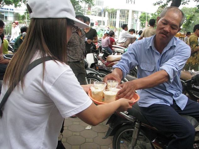 Các bác phụ huynh đang đón nhận ly tào phớ từ nhóm "từ thiện thật".