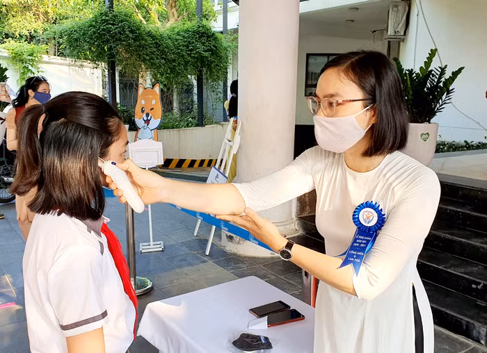 Học sinh được đo nhiệt độ. Ảnh: H.V