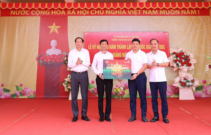 Ông Đinh Tiến Hải, Giám đốc Quỹ bảo trợ trẻ em Việt Nam (ngoài cùng bên phải) và ông Hồng Quang, Thành viên Hội đồng quản trị, Chủ tịch Công đoàn Vietcombank (thứ 2 từ phải sang) trao biển tượng trưng 80 suất học bổng cho 6 trường trên địa bàn xã Tân Trào, tỉnh Tuyên Quang. anh-1-12.jpg