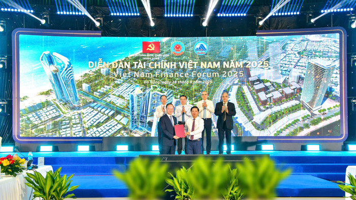 Ông Lê Quang Vinh - Tổng Giám đốc Vietcombank (bên trái) và ông Lương Nguyễn Minh Triết - Ủy viên dự khuyết Ban Chấp hành Trung ương Đảng, Chủ tịch Ủy ban nhân dân Thành phố Đà Nẵng trao biên bản ghi nhớ hợp tác trước sự chứng kiến của Đoàn Chủ tọa phiên toàn thể Diễn đàn tài chính thường niên Việt Nam năm 2025. 2025082-vcb-va-ubnd-tp-da-nang-hop-tac-phat-trien-dich-vu-tai-tt-tai-chinh-quoc-te-vn-1.jpg