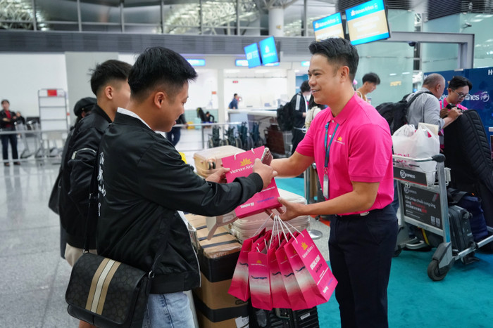 Nhân viên mặt đất Vietnam Airlines trao quà tặng tới hành khách trước khi khởi hành. a2.jpg