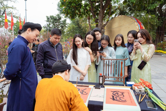 Các bạn trẻ nô nức xin chữ thầy đồ trong không gian hoa xuân Lý Thái Tổ.