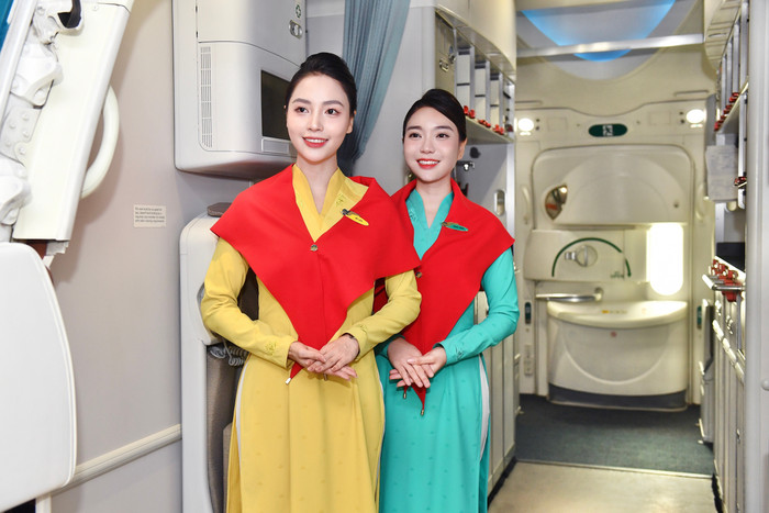 Tiếp viên Vietnam Airlines quàng khăn đỏ sao vàng, nở nụ cười chào đón hành khách trong không khí lễ hội. 2-tiep-vien-vietnam-airlines-quang-khan-do-sao-vang-no-nu-cuoi-chao-don-hanh-khach-trong-khong-khi-le-hoi.jpg