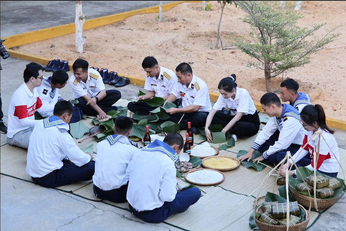 Các cán bộ, chiến sĩ và đoàn công tác cùng gói từng chiếc bánh chưng.