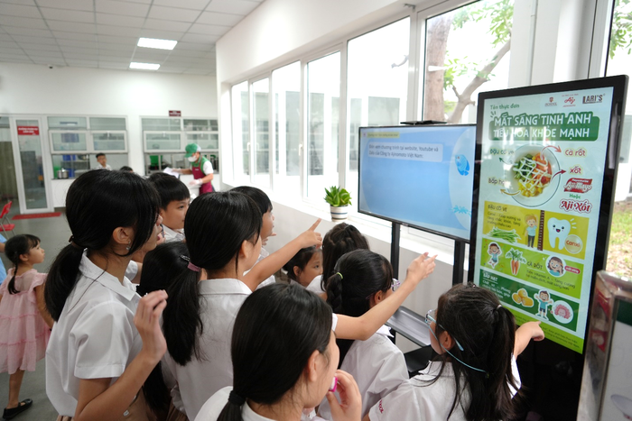 Học sinh hào hứng tìm hiểu giá trị dinh dưỡng của các loại rau củ sẽ được ăn trong bữa trưa tại trường.