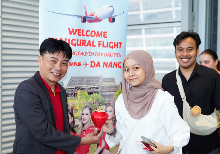 Đại diện Vietjet - Giám đốc Văn phòng Miền Trung Vietjet - ông Trần Hoàng Linh chào đón và tặng quà hành khách trên chuyến bay khai trương. a6-17.jpg