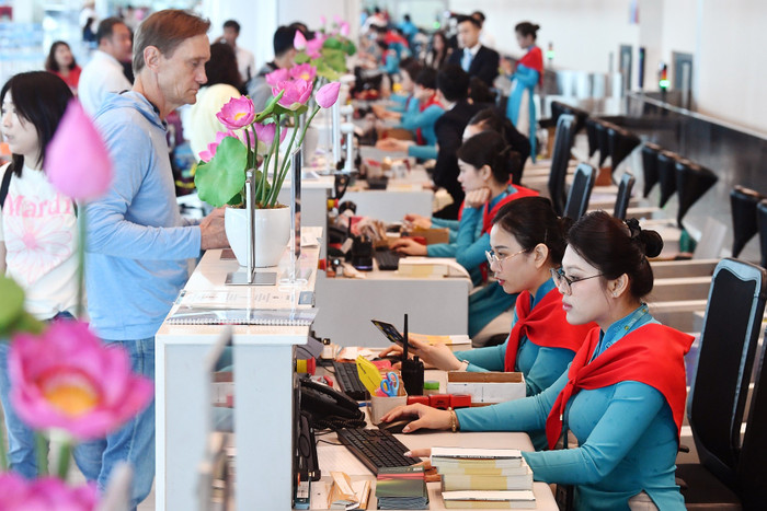 Quầy làm thủ tục tại sân bay rộn ràng sắc đỏ sao vàng, hành khách nhận thẻ lên tàu phiên bản đặc biệt in biểu tượng 2/9. 1-quay-lam-thu-tuc-tai-san-bay-ron-rang-sac-do-sao-vang-hanh-khach-nhan-the-len-tau-phien-ban-dac-biet-in-bieu-tuong-2-9.jpg