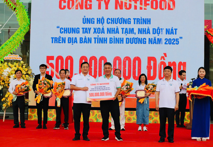 Ông Trần Thanh Sơn - Giám đốc Nhà máy Bình Dương đại diện Nutifood trao bảng tượng trưng cho ông Võ Văn Minh - Chủ tịch Ủy ban nhân dân tỉnh Bình Dương. hinh-1.jpg