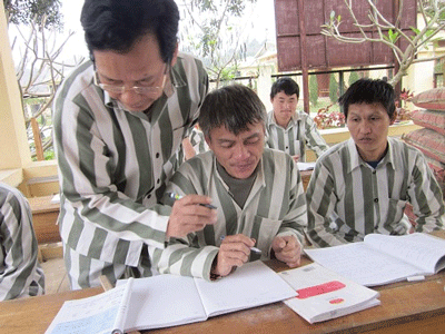 Sầm Đức Xương đang dạy chữ cho các bạn tù Sầm Đức Xương đang dạy chữ cho các bạn tù