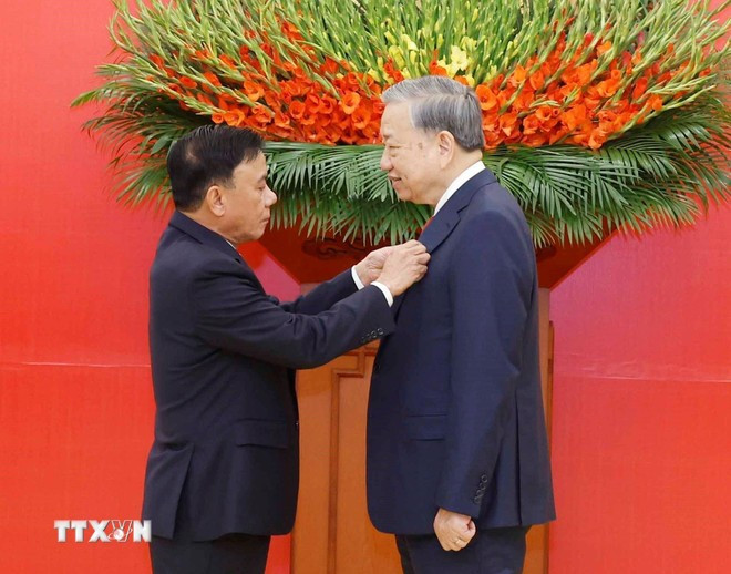 Đồng chí Trần Cẩm Tú, Ủy viên Bộ Chính trị, Thường trực Ban Bí thư trao Huy hiệu Đảng và tặng hoa chúc mừng Tổng Bí thư Tô Lâm. Ảnh: Thống Nhất/TTXVN