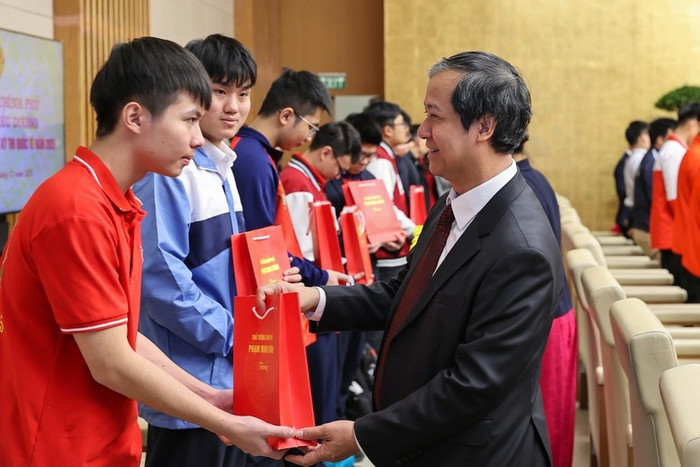 Bộ trưởng Bộ Giáo dục và Đào tạo Nguyễn Kim Sơn tặng quà các em học sinh đoạt giải tại các kỳ thi quốc tế năm 2025. Ảnh: VGP/Nhật Bắc