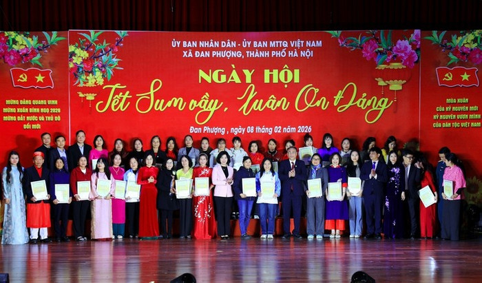 Bà Phùng Thị Hồng Hà cùng các đồng chí lãnh đạo xã Đan Phượng chụp ảnh lưu niệm với các đội đạt giải trong cuộc thi gói bánh chưng xanh và trang trí mâm ngũ quả. Ảnh: hanoi.gov.vn.