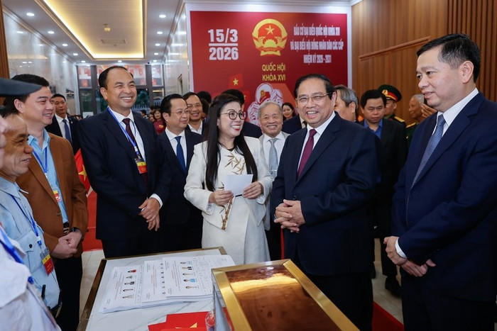 Thủ tướng Chính phủ Phạm Minh Chính và Phu nhân trò chuyện với cử tri khu vực bỏ phiếu số 21. Ảnh: baochinhphu.vn.