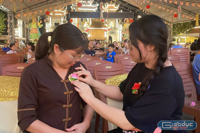 Em Nguyễn Phương Vy cài hoa lên ngực áo của mẹ - chị Nguyễn Thị Thu Hà. gdvn-chi-ha.jpg