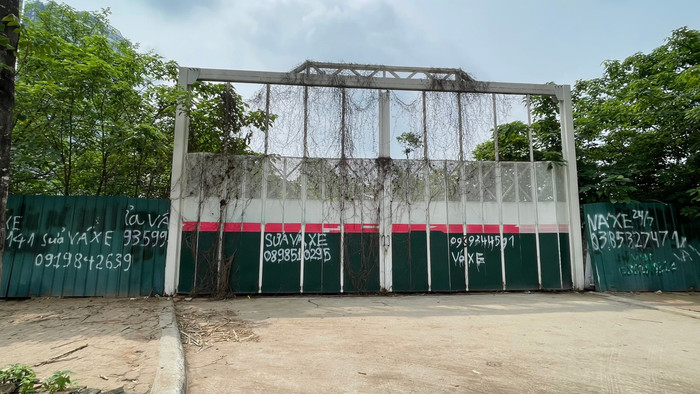 Lối cổng ra vào khu đất dự án trên đường Châu Văn Liêm luôn đóng cửa, có thể thấy phía trong cây dại mọc um tùm. Ảnh: Trung Dũng xp7.jpg