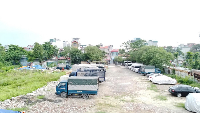 Phía trong ô đất có nhiều xe tải tập kết, một số xe con còn đang phủ bạt. Người trông coi khu đất nói, nơi này nhận trông giữ xe ô tô theo ngày hoặc theo tháng. Ảnh: Trung Dũng 1-17.jpg