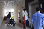 Thí sinh chống nạng được bảo vệ hỗ trợ đưa lên phòng thi
