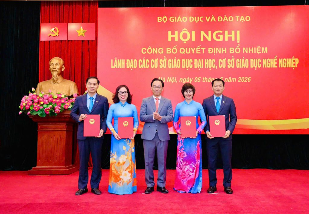 Bộ trưởng Bộ trưởng Bộ Giáo dục và Đào tạo trao Quyết định, chúc mừng Hiệu trưởng và các Phó Hiệu trưởng Trường Đại học Mở Hà Nội. Ảnh: NTCC