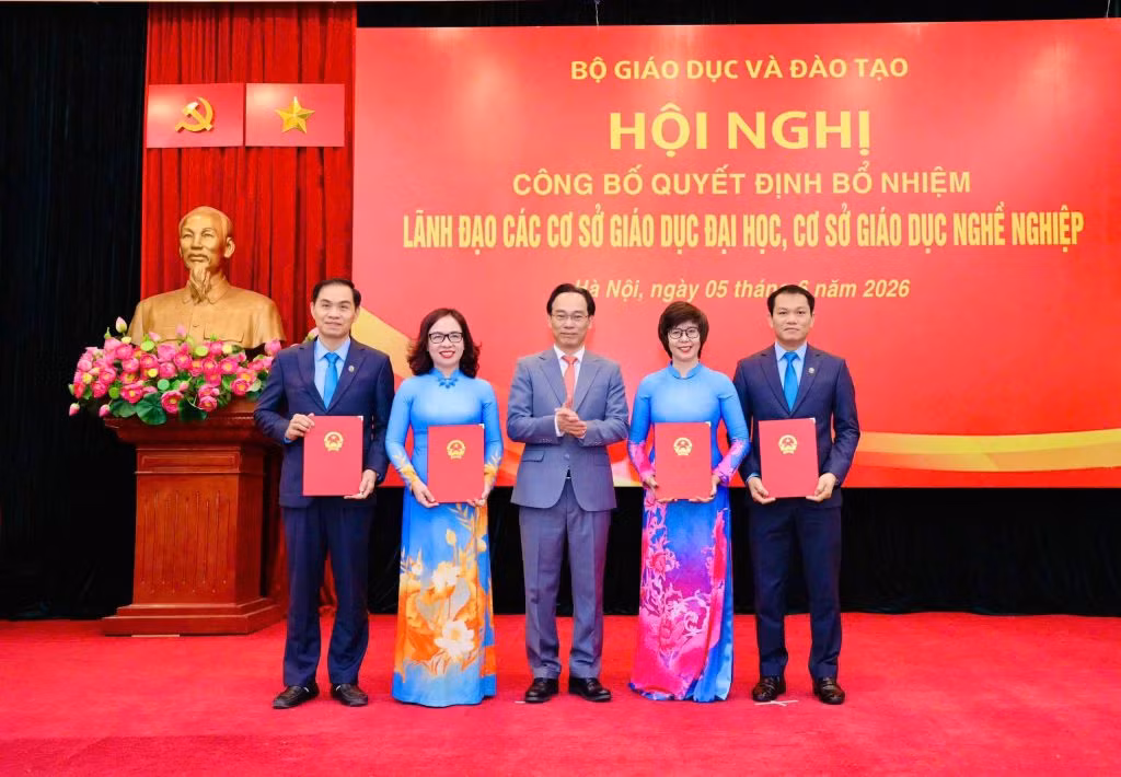 Bộ trưởng Bộ trưởng Bộ Giáo dục và Đào tạo trao Quyết định, chúc mừng Hiệu trưởng và các Phó Hiệu trưởng Trường Đại học Mở Hà Nội. Ảnh: NTCC