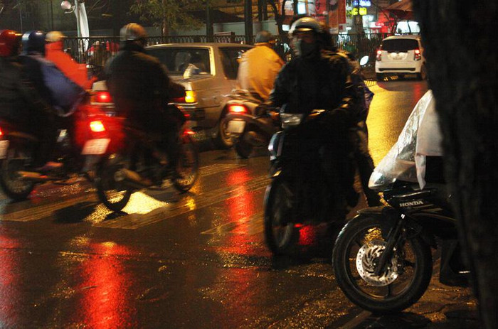 Đã hơn một lần định kéo tay ga để sang đường nhưng lại vướng xe máy đi ngược đường nên cô gái đành giảm ga.