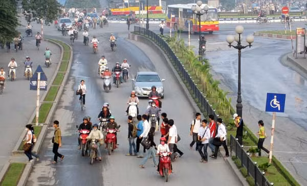 Người đi bộ không đi lên cầu vượt bộ hành mà lại đi vào đường dành cho người khuyết tật ở trạm trung chuyển xe buýt Cầu Giấy. Ảnh: Giàng A Cối