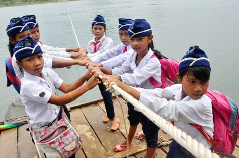 Để đến được trường, các em học sinh Trường TH Sơn Ba phải đánh cược tính mạng của mình với "hà bá" trên những chiếc bè như này.