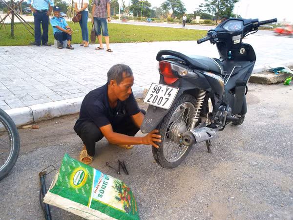 Hàng ngày, ngoài công việc làm thuê chú Định còn tranh thủ đi vá xăm xe. Ảnh Xuân Trung