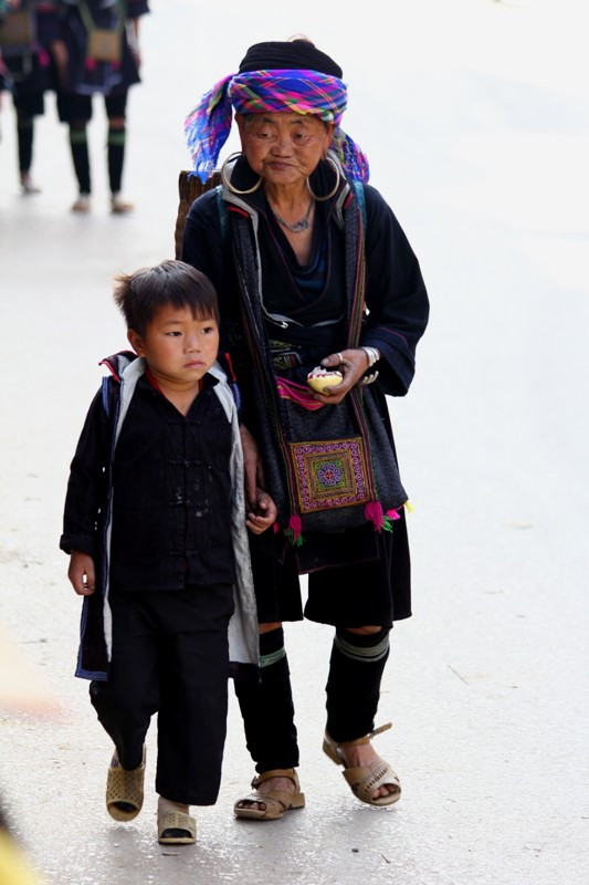 Em bé này cùng bà xuống chợ bán khoai, những củ khoai được bà địu trong những chiếc giỏ to. Em bé này cùng bà xuống chợ bán khoai, những củ khoai được bà địu trong những chiếc giỏ to.