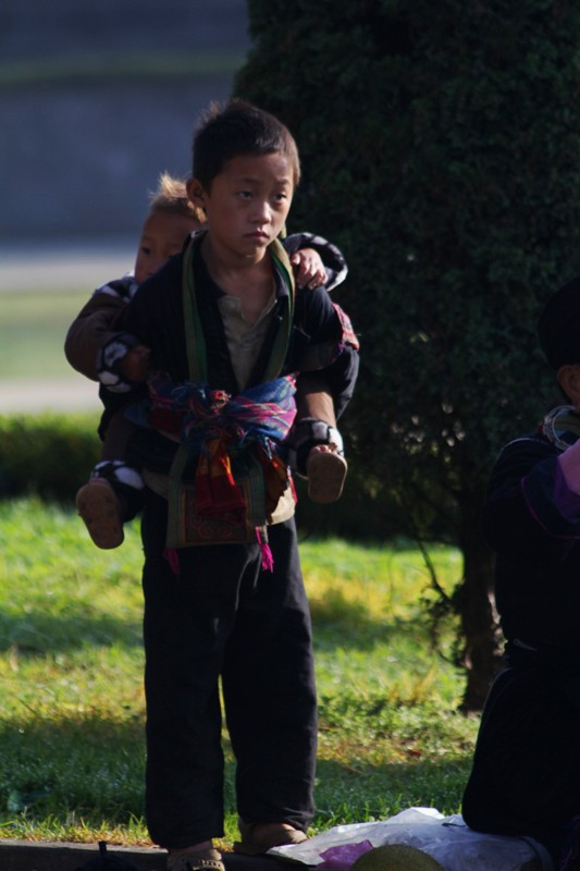 Hai anh em núp sau bóng mẹ bán hàng từ sáng sớm cho tới trưa. Khi chúng tôi trở lại vẫn thấy hai anh em cõng nhau chờ mẹ bán nốt mấy tấm vải dệt thổ cẩm bằng tay. Hai anh em núp sau bóng mẹ bán hàng từ sáng sớm cho tới trưa. Khi chúng tôi trở lại vẫn thấy hai anh em cõng nhau chờ mẹ bán nốt mấy tấm vải dệt thổ cẩm bằng tay.