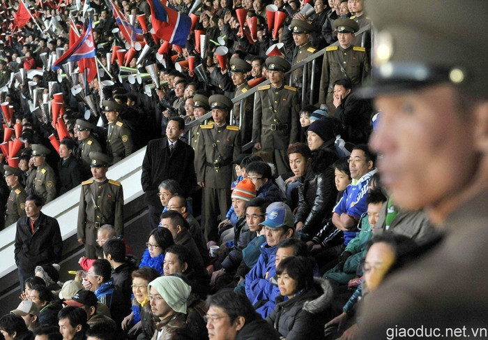 Nhân viên an ninh Triều Tiên giám sát chặt chẽ các cổ động viên của tuyển Nhật Bản (áo xanh).Trong khi đó, phía bên cạnh, các cổ động của đội chủ nhà tha hồ la hét, cổ vũ thoải mái. Nhân viên an ninh Triều Tiên giám sát chặt chẽ các cổ động viên của tuyển Nhật Bản (áo xanh).Trong khi đó, phía bên cạnh, các cổ động của đội chủ nhà tha hồ la hét, cổ vũ thoải mái.