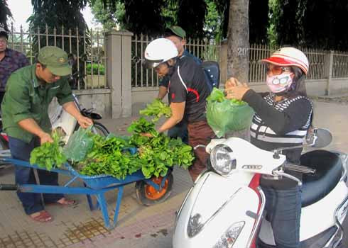 Nhiều người ghé mua rau của các chú bộ đội trên đường Hoàng Hoa Thám. Ảnh: Quốc Bảo
