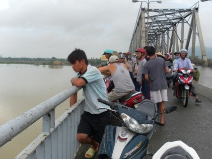 Nhiều người dân hiếu kỳ và gia đình nạn nhân đang tìm kiếm quanh vực cầu Bên Thủy nơi nghi ngờ em Anh tự tử
