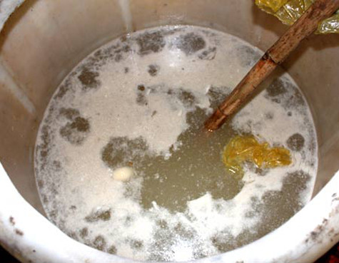 Hàng trăm thùng ngâm nguyên liệu dùng để ngâm mứt cáu bẩn bốc mùi hôi nồng cả khu vực chế biến. Khay chậu đựng mứt được đặt luôn dưới nền nhà.