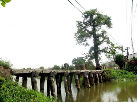 Chùa nằm trong một quần thể di tích lịch sử gắn liền với quá trình thành lập làng Nôm. Đó là đình Tam Giang thờ vị tướng thời Hai Bà Trưng. Đó là cây cầu đá gồm 9 nhịp đầu rồng đã mấy trăm năm nay soi bóng xuống dòng sông Nguyệt Đức, nâng bước chân thiện nam tín nữ đến với chùa. Chiếc cầu đá bắc qua bờ sông này đã tồn tại trên 200 năm (Ảnh: Internet). Chùa nằm trong một quần thể di tích lịch sử gắn liền với quá trình thành lập làng Nôm. Đó là đình Tam Giang thờ vị tướng thời Hai Bà Trưng. Đó là cây cầu đá gồm 9 nhịp đầu rồng đã mấy trăm năm nay soi bóng xuống dòng sông Nguyệt Đức, nâng bước chân thiện nam tín nữ đến với chùa. Chiếc cầu đá bắc qua bờ sông này đã tồn tại trên 200 năm (Ảnh: Internet).