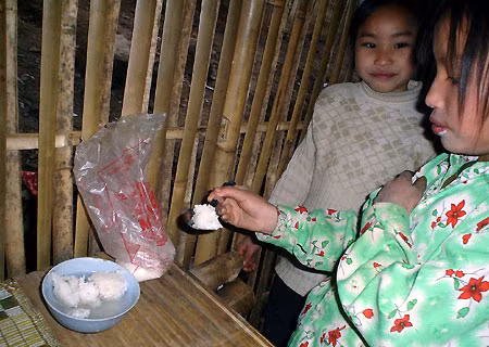 hơn nữa thì ăn cơm nguội với nước lã, rắc vài hạt muối trắng. Bữa ăn của em Lý Thị Mỵ - HS trường phổ thông cơ sở Thái Sơn.