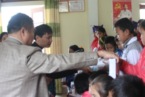 Đại diện Công ty TNHH Thương mại – Dịch vụ - Du lịch Phạm Tĩnh Gia Bảo, Quỹ Nhất nam ươm mầm Nhân ái trao quà cho các em có hoàn cảnh khó khăn vươn lên trong học tập tại xã Châu Phong, huyện Quỳ Châu, Nghệ An