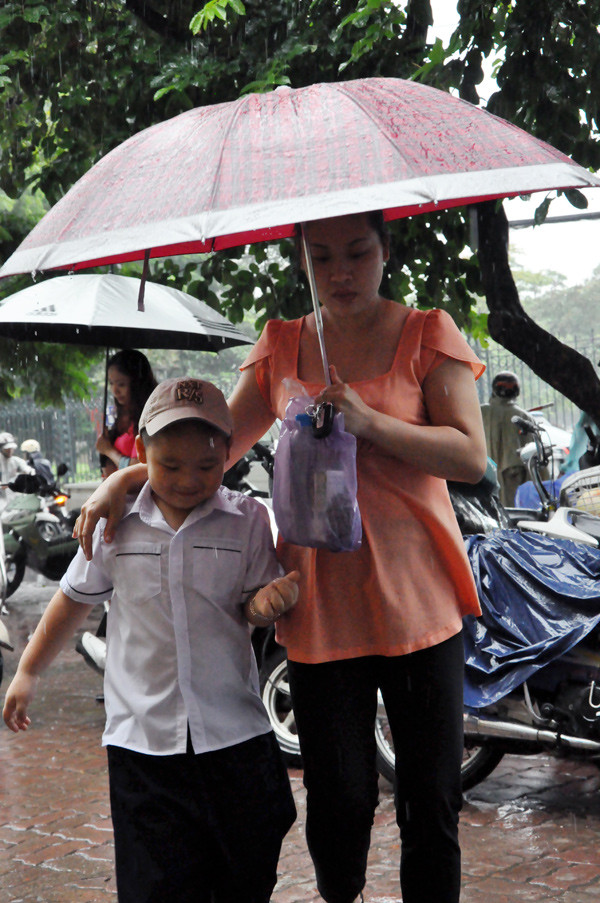 Che ô cho con tới trường. Che ô cho con tới trường.