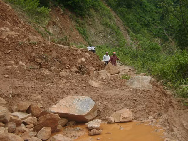 Đất đá sạt lở ngổn ngang xuống lòng đường, chắn ngang hết lối đi