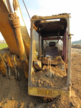 Khoang buồng lái của chiếc xe ép cọc cát bị vỡ hết kính, đất đá ngập đầy phía trong. Khoang buồng lái của chiếc xe ép cọc cát bị vỡ hết kính, đất đá ngập đầy phía trong.