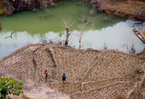 Hai người bước trên thửa ruộng sau khi bị ngập nước. Hai người bước trên thửa ruộng sau khi bị ngập nước.