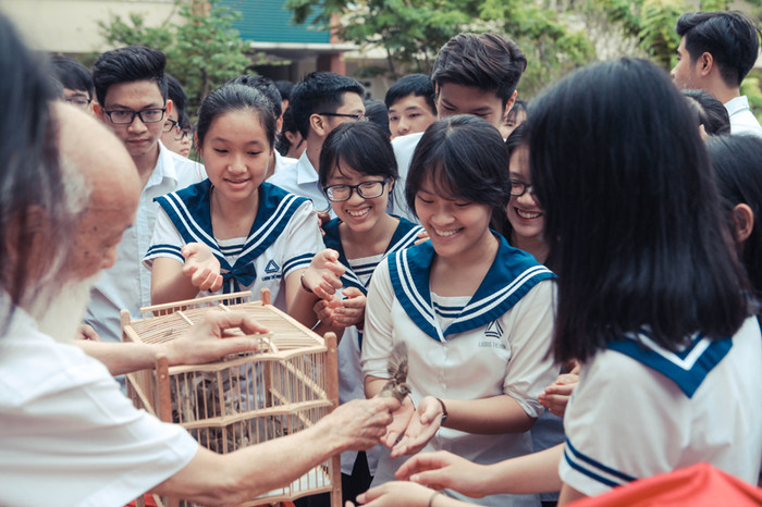 Thầy Cương tận tay giúp các trò cầm từng chú chim ra khỏi lồng để chuẩn bị thả.