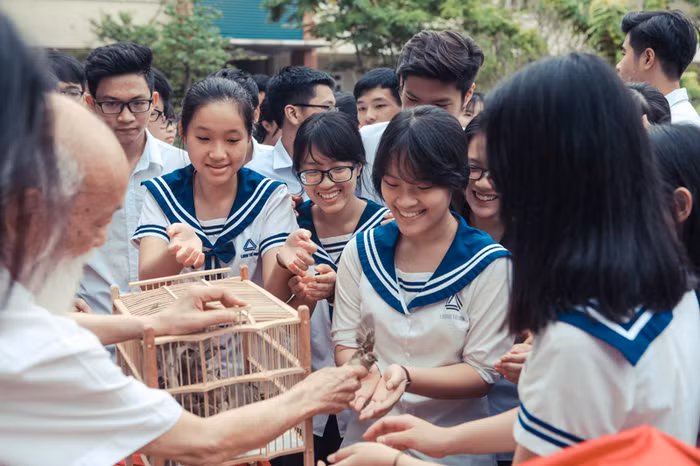 Thầy Cương tận tay giúp các trò cầm từng chú chim ra khỏi lồng để chuẩn bị thả.