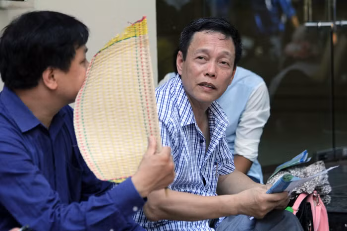 Hầu như các vị phụ huynh đều mang theo chiếc quạt nan để tránh nóng.