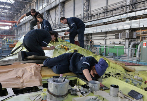 Công nhân đang làm việc trên lưng máy bay Công nhân đang làm việc trên lưng máy bay