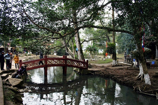 Chiếc cầu sơn đỏ nho nhỏ dẫn vào đền thờ Chàng Rắn. Tương truyền chàng là người đã có công lập làng giữ bản chống chọi với thiên tai giặc giã, mưu cầu bình an, thóc lúa khoai sắn đầy bồ, rượu đầy chum đầy choé. Chiếc cầu sơn đỏ nho nhỏ dẫn vào đền thờ Chàng Rắn. Tương truyền chàng là người đã có công lập làng giữ bản chống chọi với thiên tai giặc giã, mưu cầu bình an, thóc lúa khoai sắn đầy bồ, rượu đầy chum đầy choé.