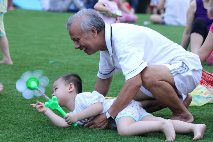 Chơi chong chóng cùng ông là một sở thích của bé trai này.