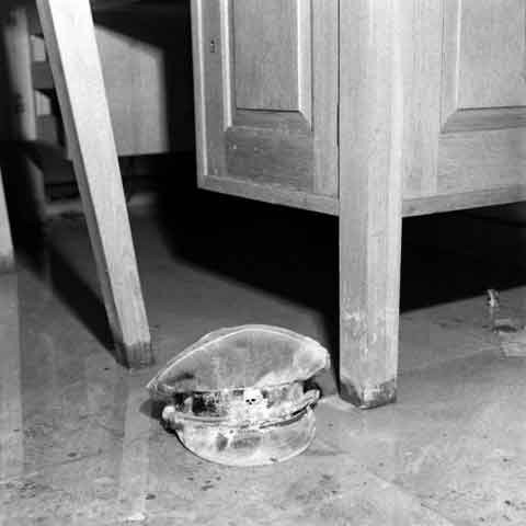 Ảnh chưa từng công bố: Mũ của một sĩ quan SS với biểu tượng đầu lâu khét tiếng nằm trên sàn của phòng khách.